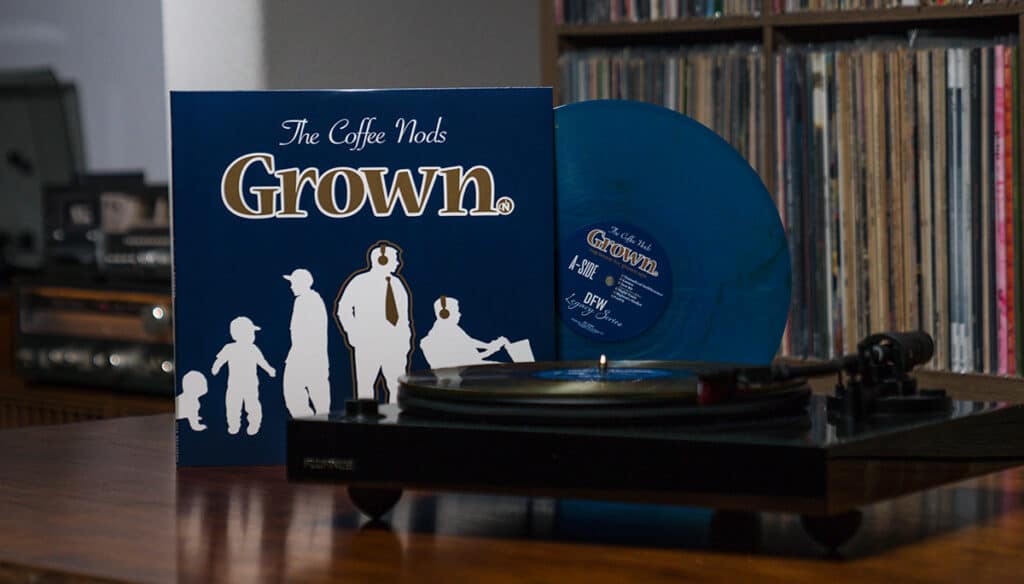 coffee nods grown blue record showing out of album jacket behind record player with gold record